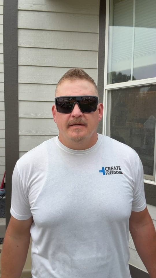 Dustin Hunter standing outside a house, speaking to the camera